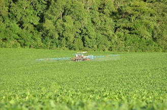 A tractor fitted with advanced water-in-fuel emulsification technology working in a lush green field.
