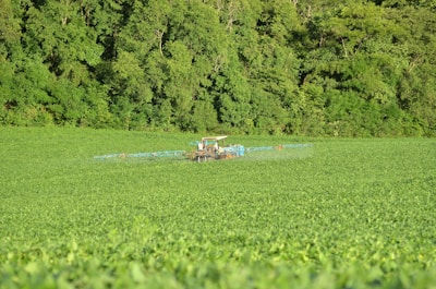 A tractor fitted with advanced water-in-fuel emulsification technology working in a lush green field.