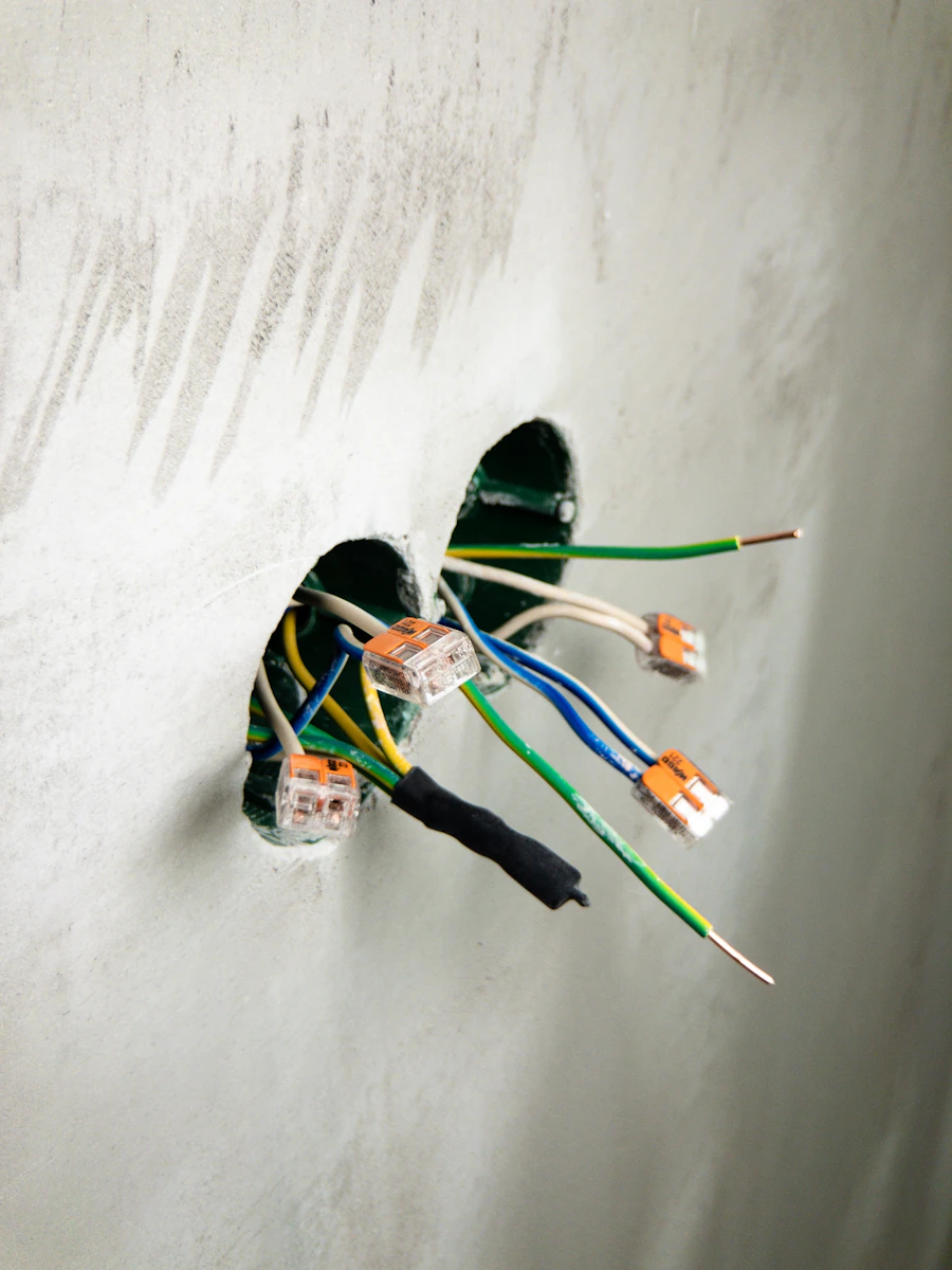 Wires and connectors in a hole in a plaster wall