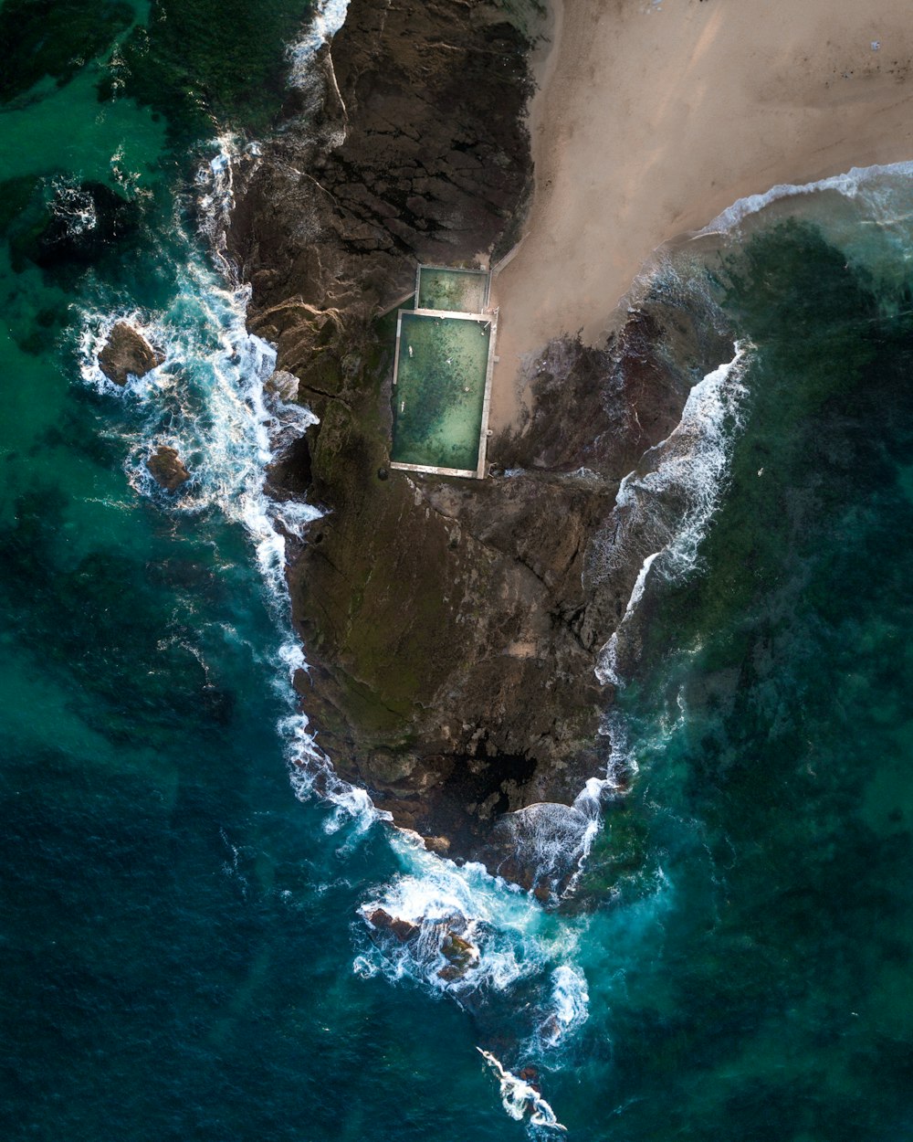 aerial photo of rock formations near sea during daytime