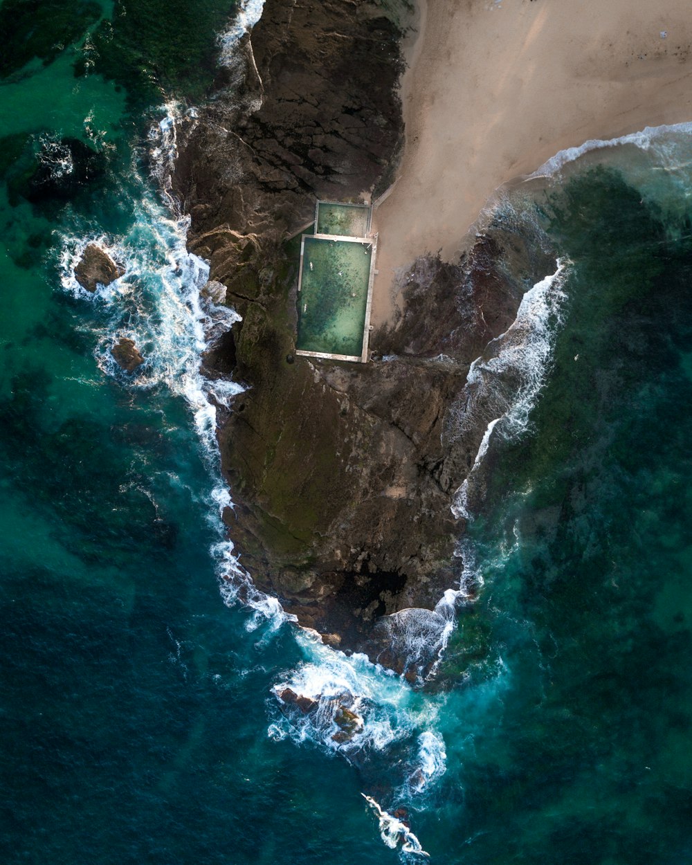 foto aérea de formações rochosas perto do mar durante o dia