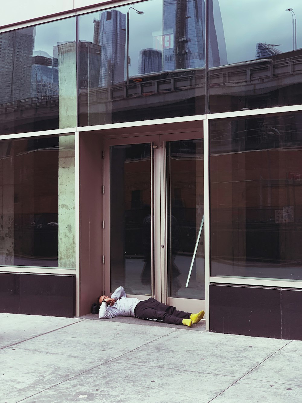 person laying beside black and white building during daytime