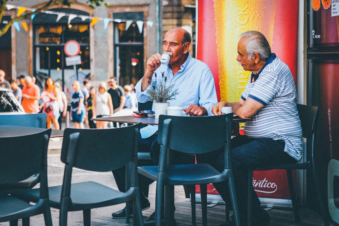 two men having coffee outside cafe