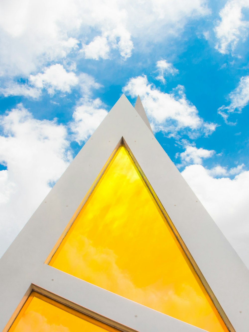 Photographie en contre-plongée d’un bâtiment jaune et blanc pendant la journée