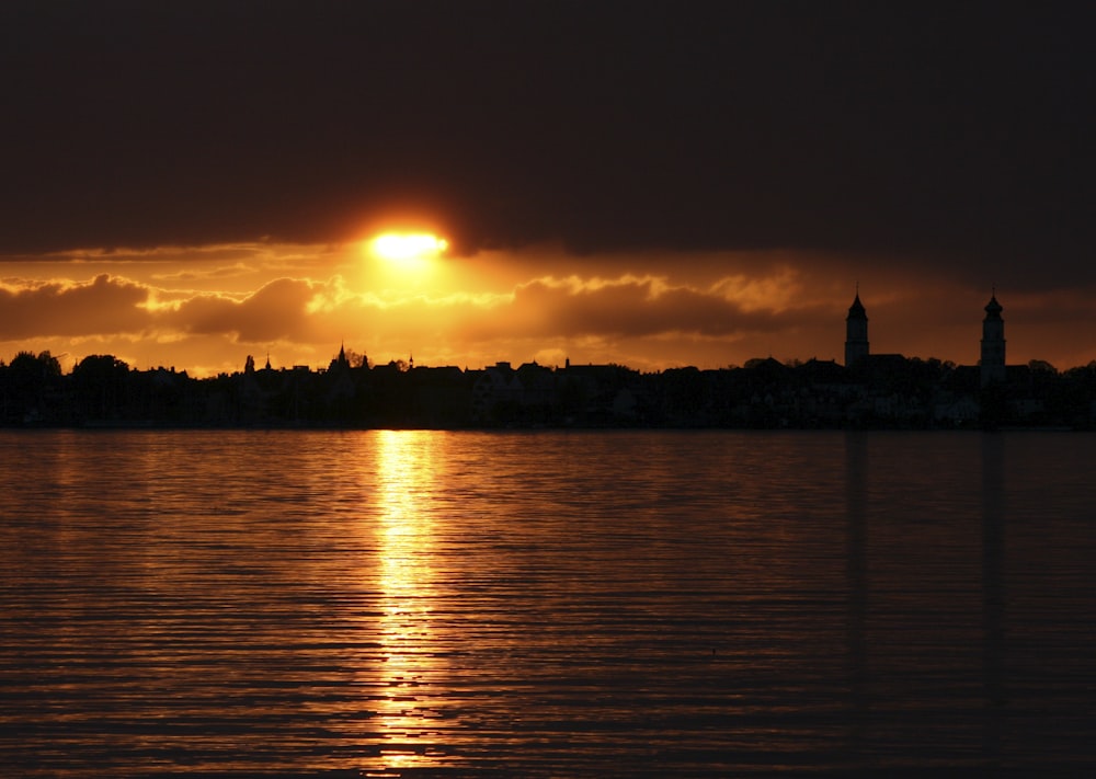 a large body of water with a sunset in the background