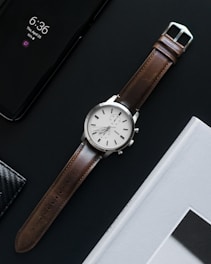 round gray analog watch with brown band