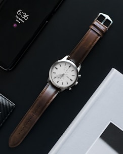 round gray analog watch with brown band