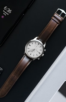 round gray analog watch with brown band