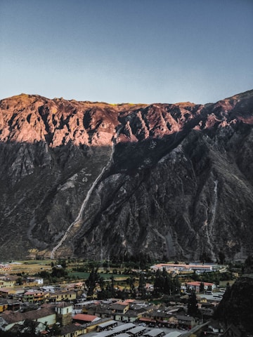 A warm, sunlit family home under construction with the Rocky Mountains towering in the background.