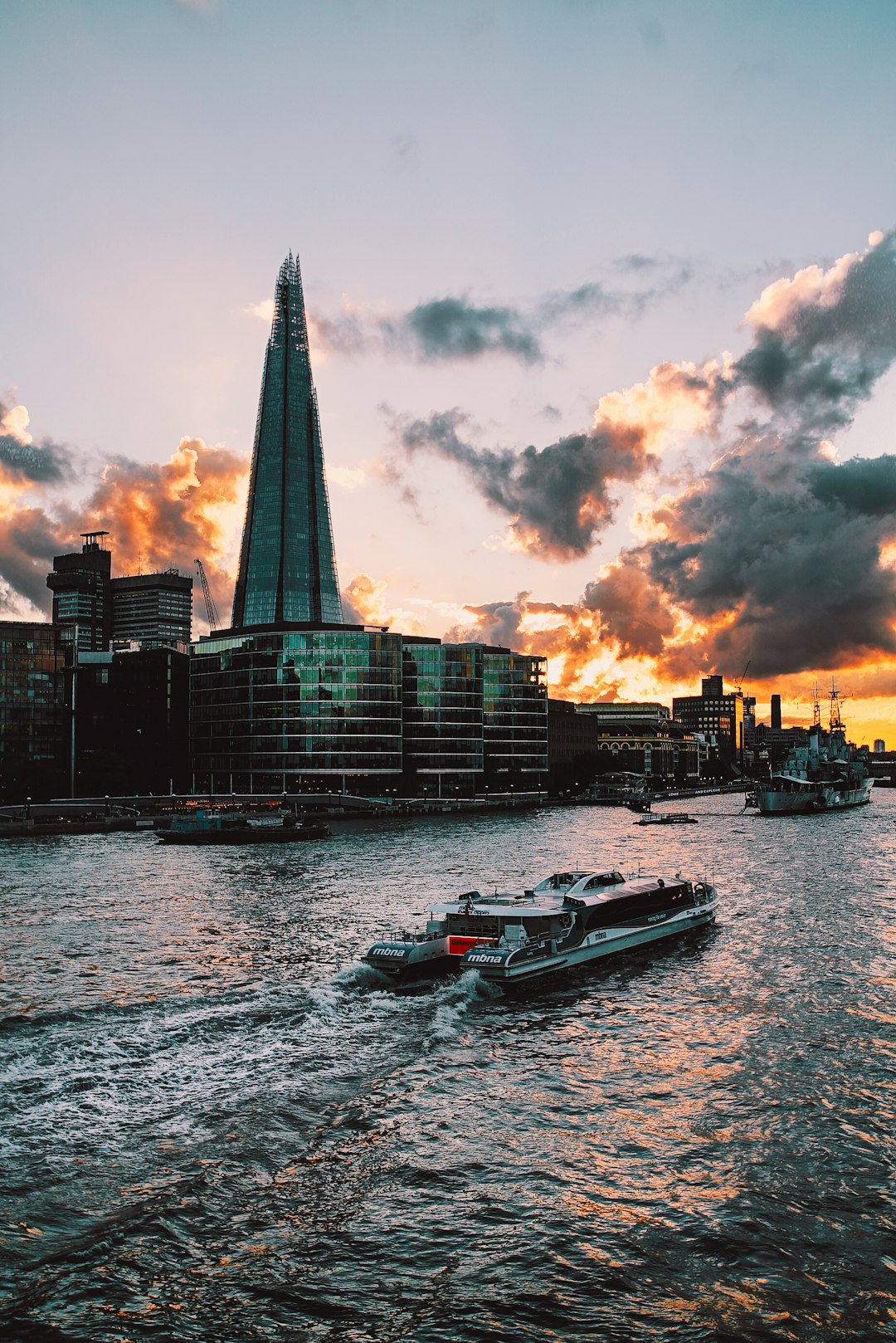 white motorized boat on body of water beside concrete building during golden hour