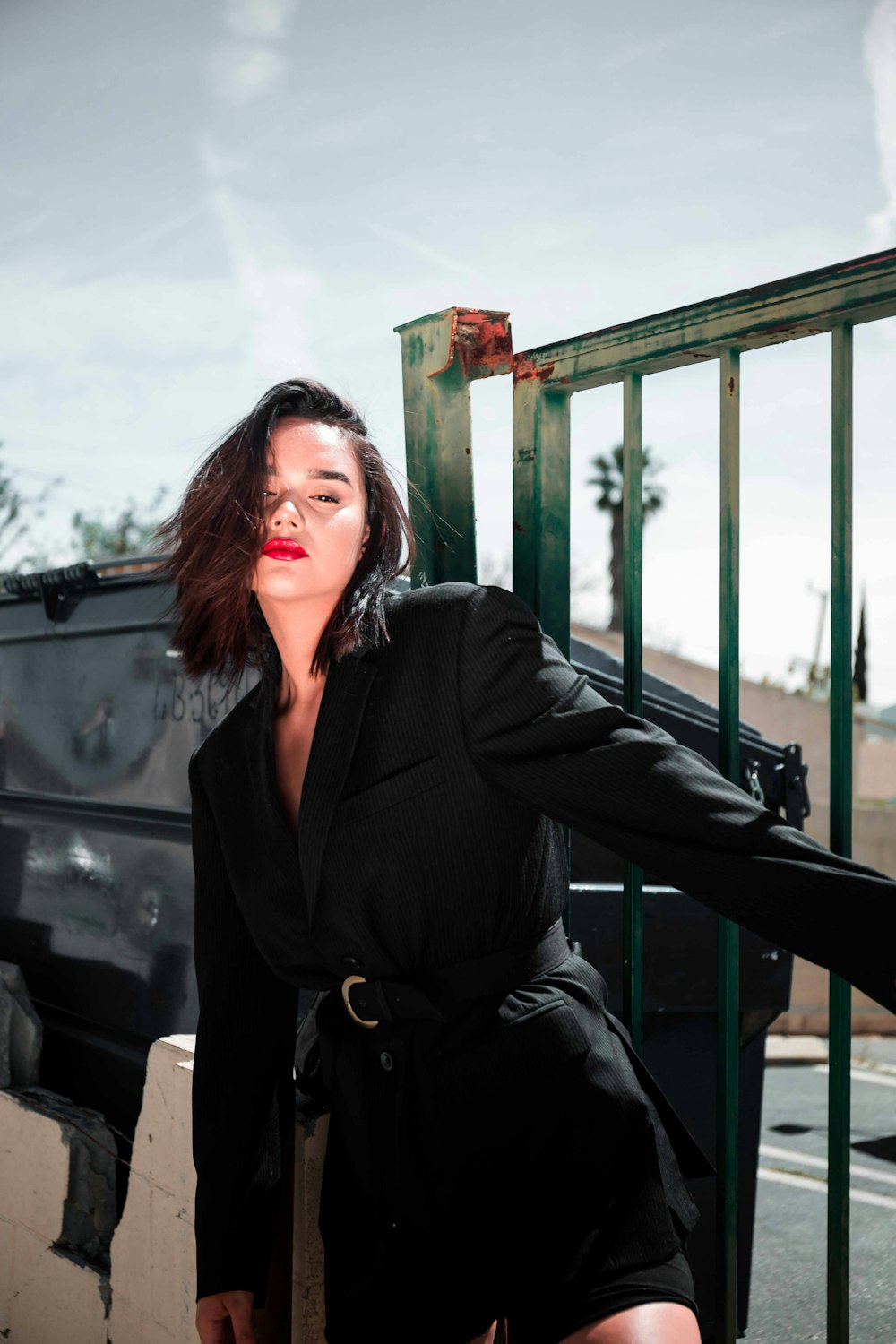 woman wearing black blazer holding grey fence