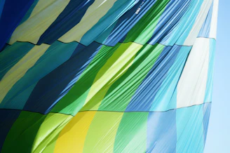 A vibrant video still showing blankets in motion, fluttering gently in a sunlit room.