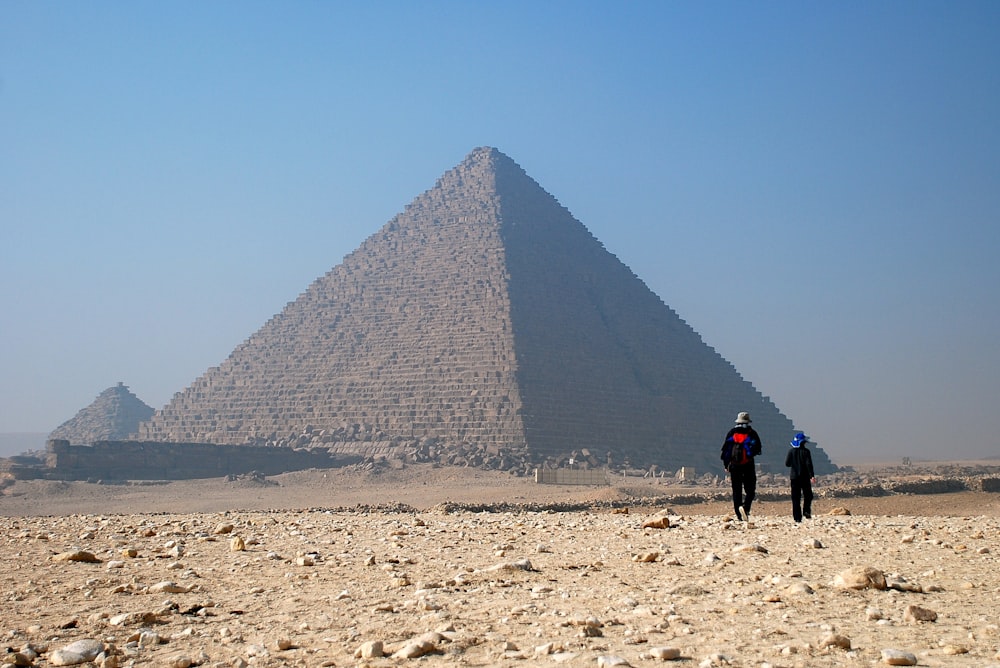 two people walking towards pyramid