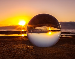 clear marble ball near seashore