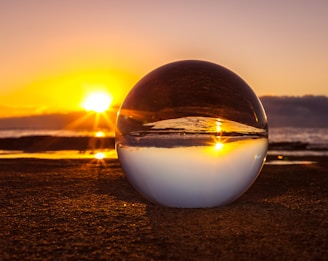 clear marble ball near seashore