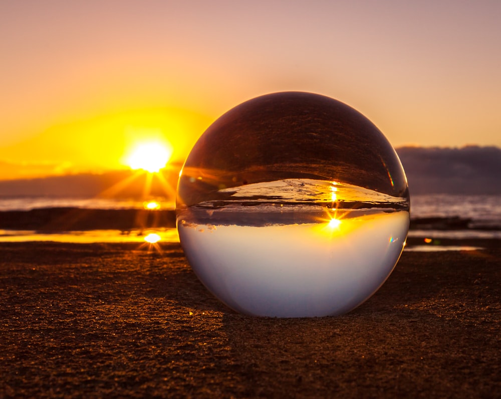 clear marble ball near seashore