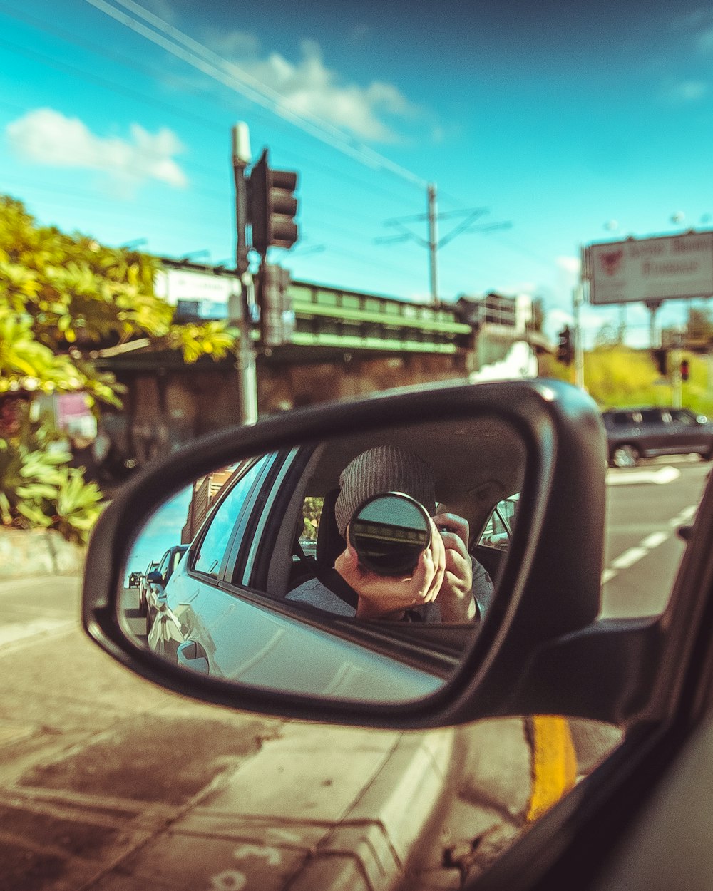 man taking photo of vehicle side mirror