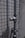 A metal pipe with a valve is mounted on a tiled wall. The wall has a pattern of small, square tiles. The surface appears weathered, suggesting exposure to outdoor elements.