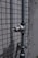 A metal pipe with a valve is mounted on a tiled wall. The wall has a pattern of small, square tiles. The surface appears weathered, suggesting exposure to outdoor elements.