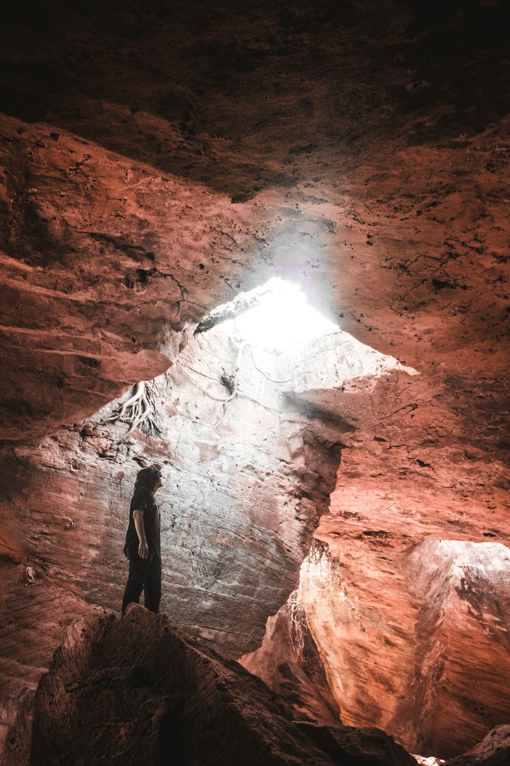 동굴 안의 바위 위에 서 있는 사람