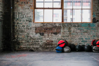 A minimalist training space with weights and recovery tools bathed in soft natural light.