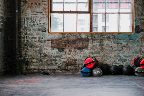 A minimalist training space with weights and recovery tools bathed in soft natural light.