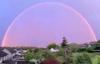 A warm, serene family scene beneath a rainbow, symbolizing connection and happiness.