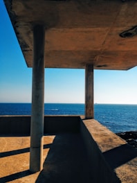 Architect reviewing blueprints with a client at a sunny beach ranch project.