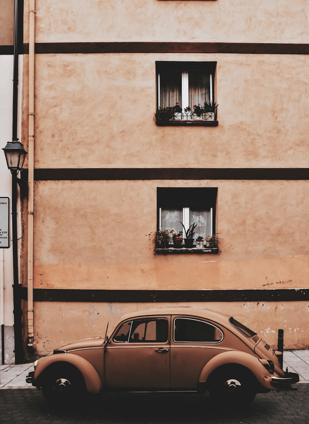 brown Volkswagen Beetle outside hous