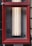 A rectangular red frame encloses a set of vertical fluorescent lights mounted against a wall. There is a small device installed on the left side within the frame. The lower section of the image includes partial text on a sign about an automatic sprinkler shut-off valve.