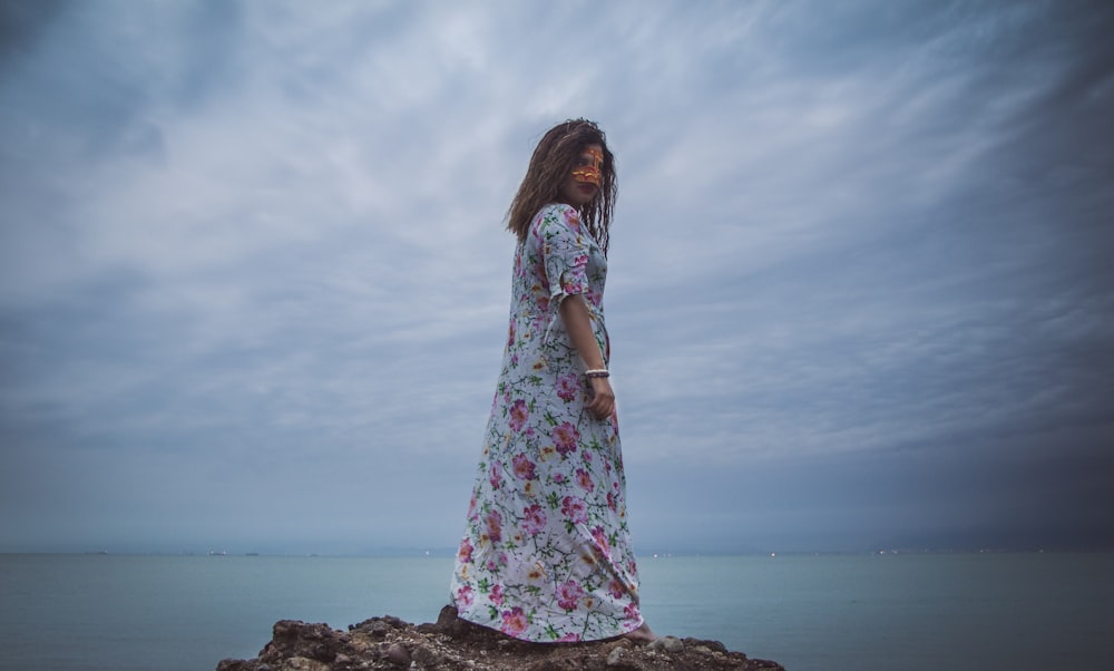 woman standing on brown rock glancing her right side