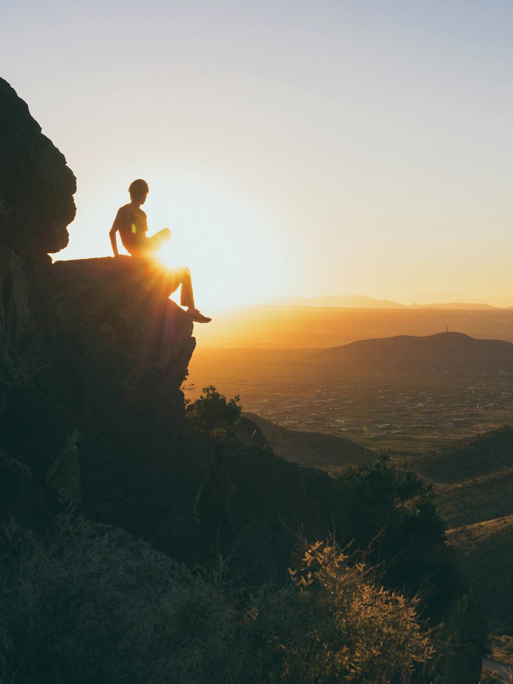 person sitting on stone during daytime