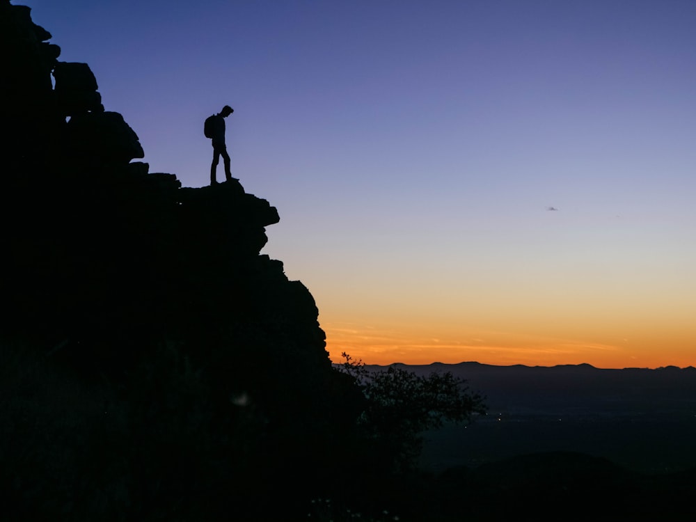 man with backpack looking overview from the cliff