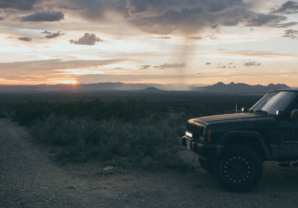 Une jeep garée sur un chemin de terre dans le désert