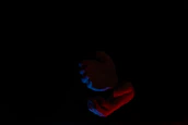 Close-up of hands performing energy healing techniques with deep red and white tones.