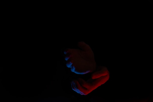 Close-up of hands in black gloves gently guiding a beginner through a safe BDSM introduction.