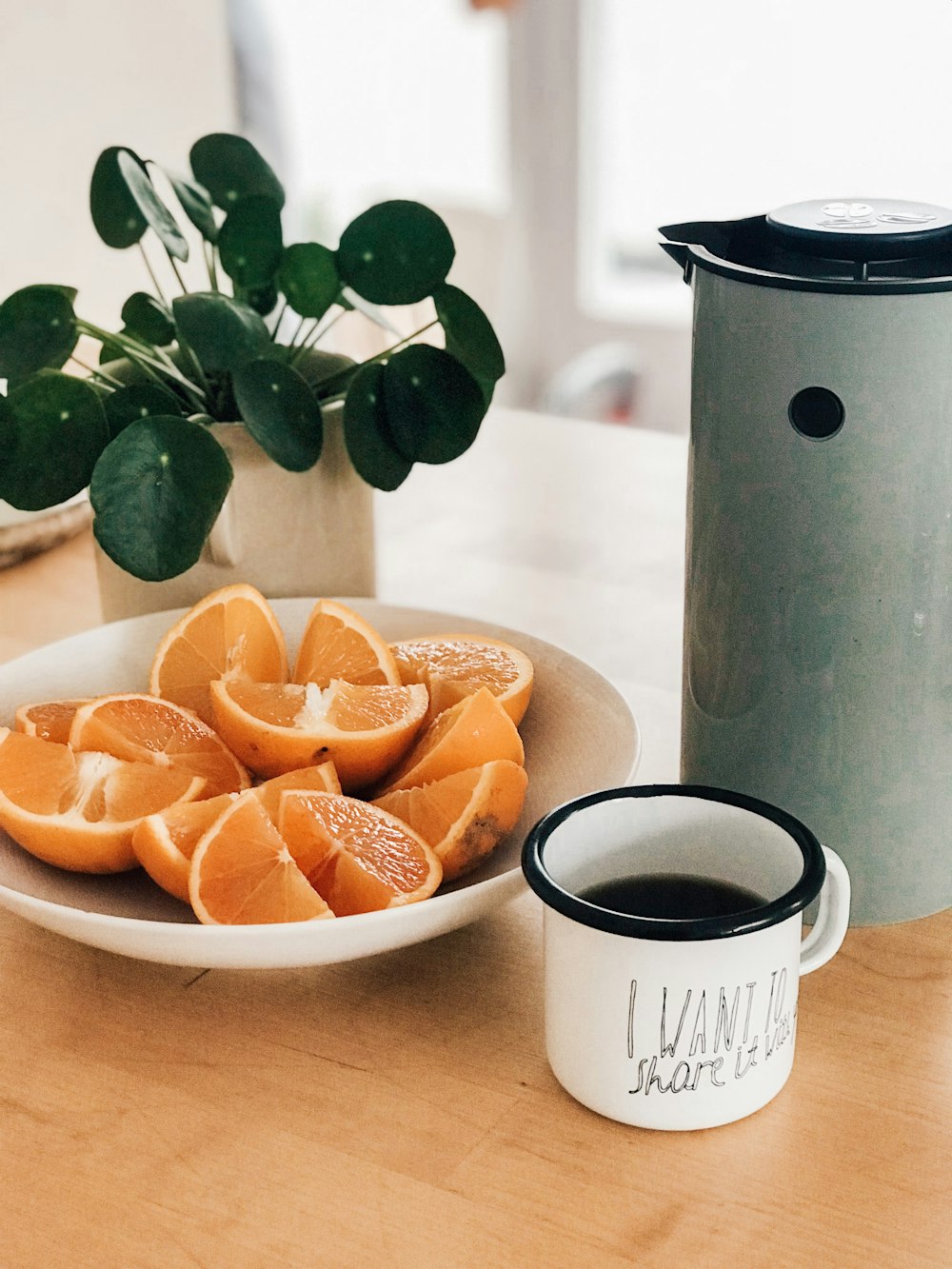 Cítricos en rodajas en un tazón blanco junto a una taza blanca