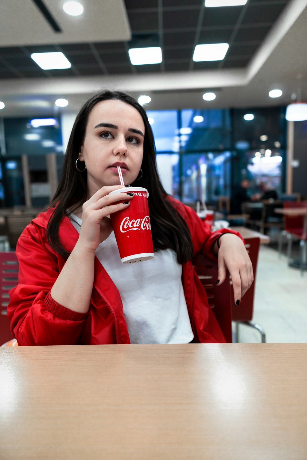 woman sitting while drinking coca-cola