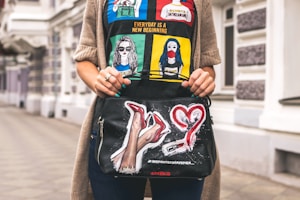 A chic black tote bag held by a woman walking in the city street.
