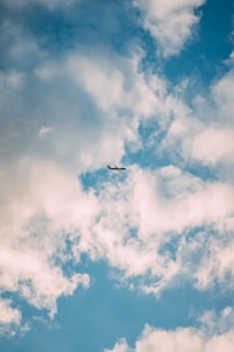 airplane under white clouds