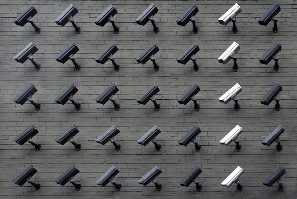 A wall-full of security cameras in shades of grey all pointing in the same direction.