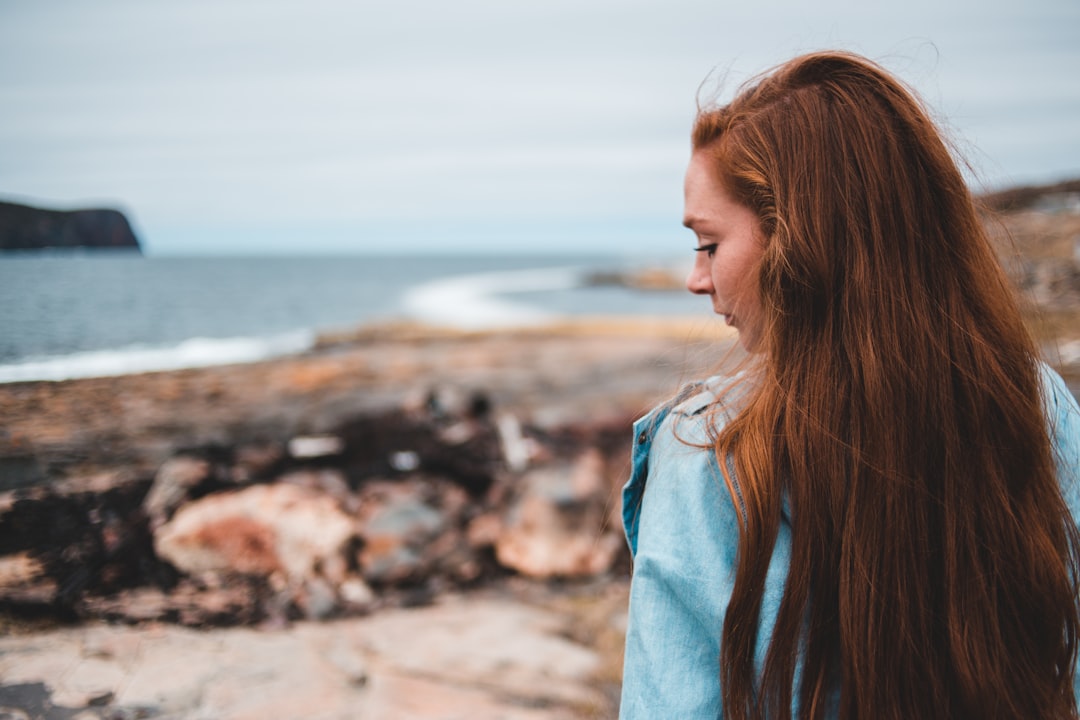 red haired woman across body of water