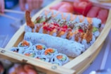 A colorful sushi boat filled with various rolls and garnishes.