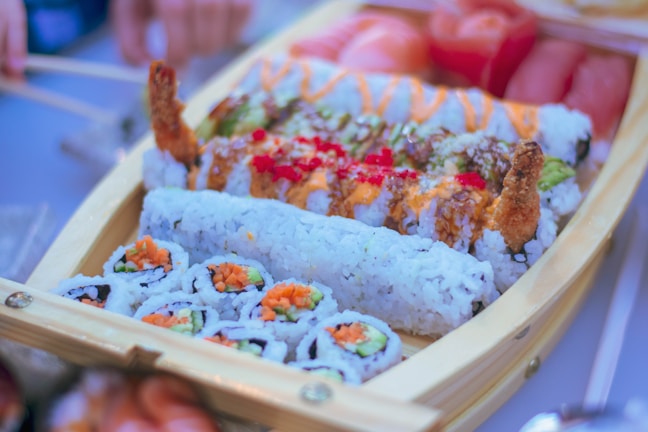 A colorful sushi boat filled with various rolls and garnishes.