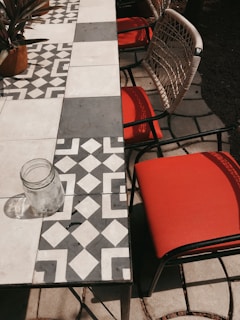 Geometric patio rug under a wooden table set, highlighting bold patterns and outdoor use.