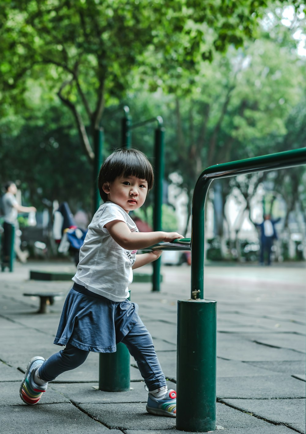 girl standing green metal post