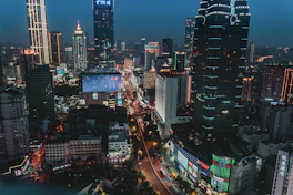 A bustling cityscape at night with glowing lights and iconic landmarks.