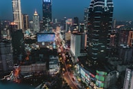 A bustling cityscape at night illuminated by glowing lights.