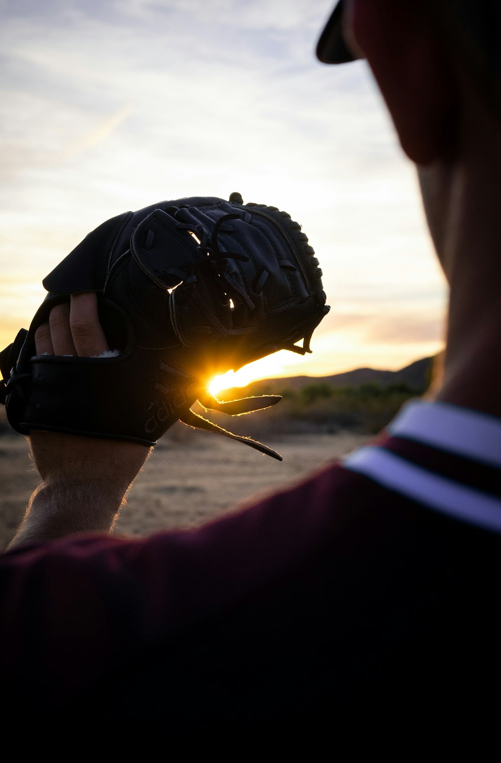 uomo che tiene guanto da baseball