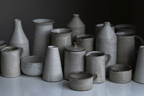 A collection of handcrafted ceramic pieces with a matte black finish on display.